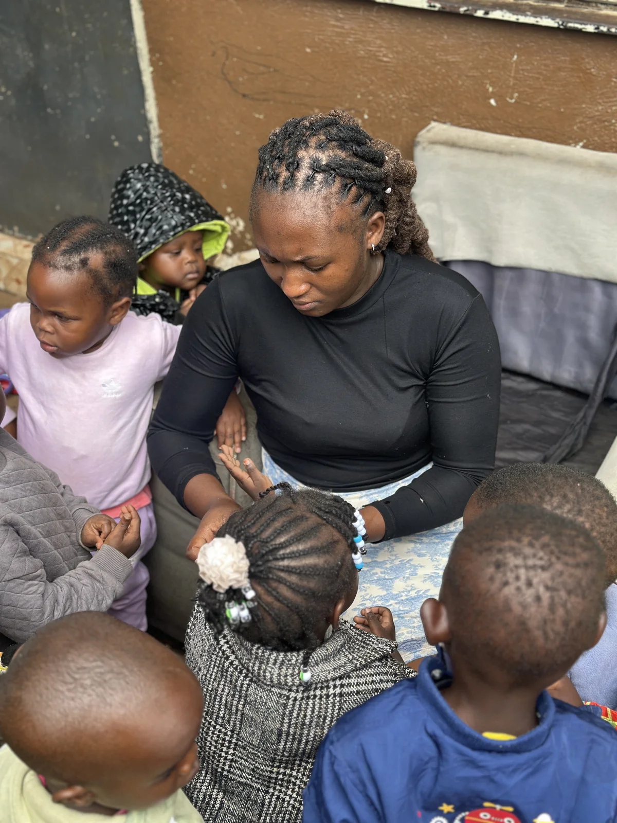 A caregiver surrounded by children