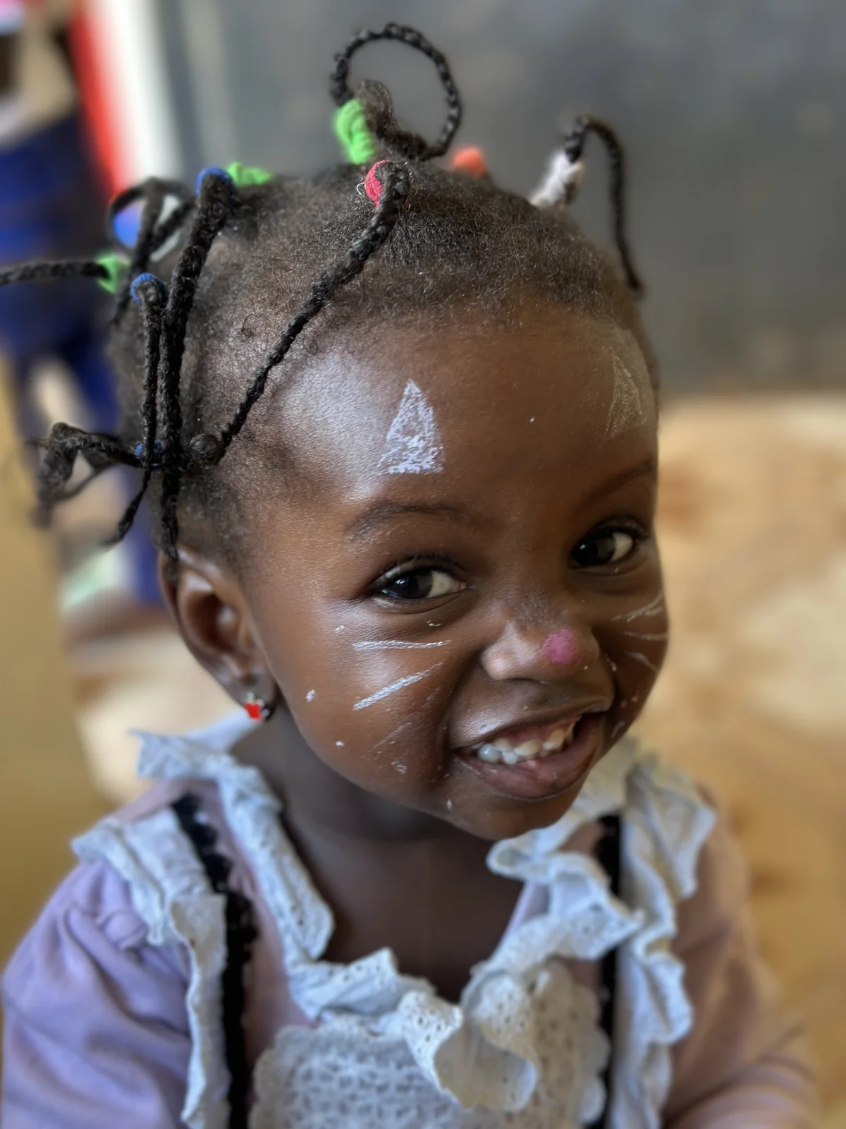 A smiling girl with face paint
