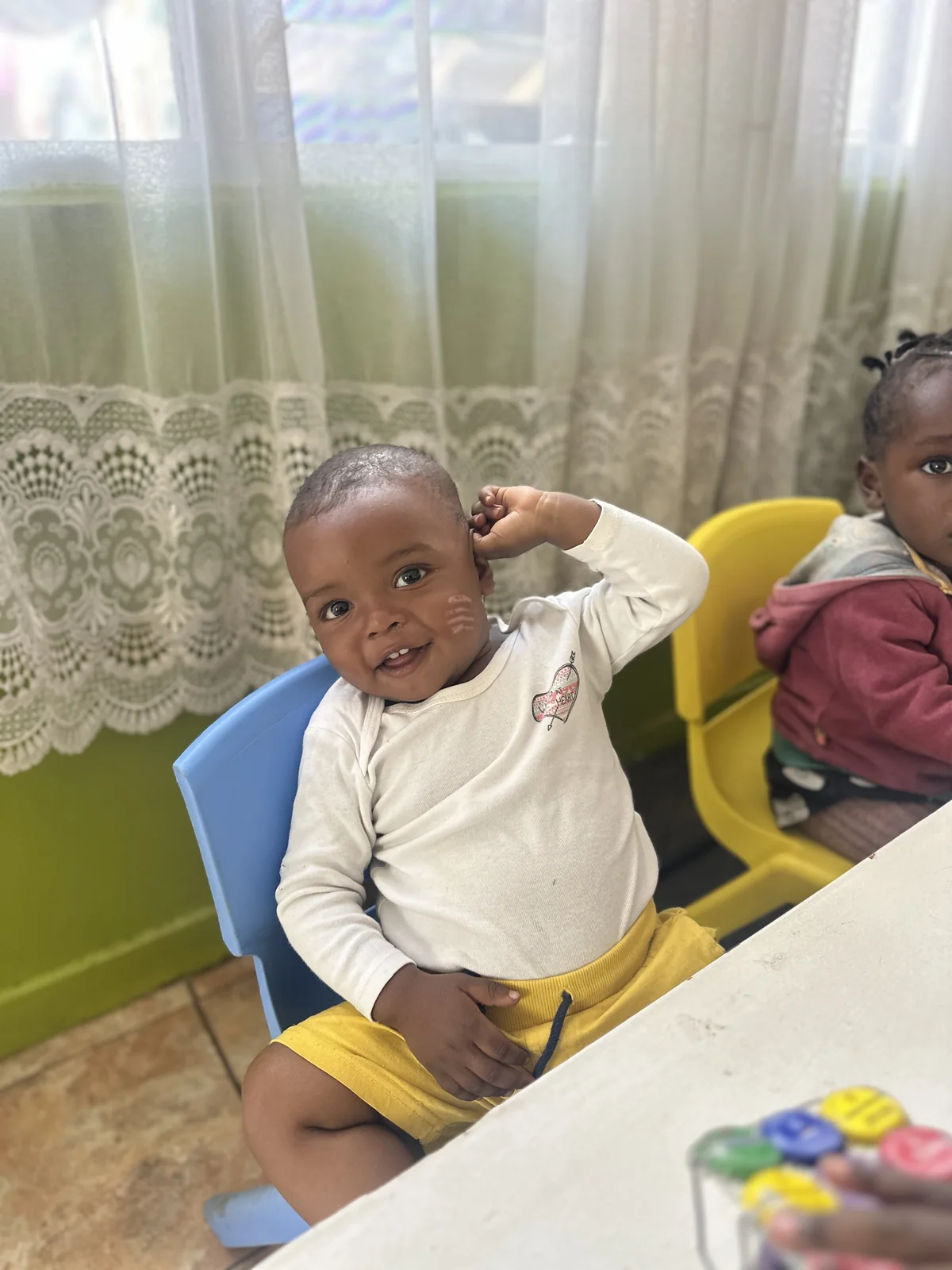 A smiling child seated in the Little Heaven room