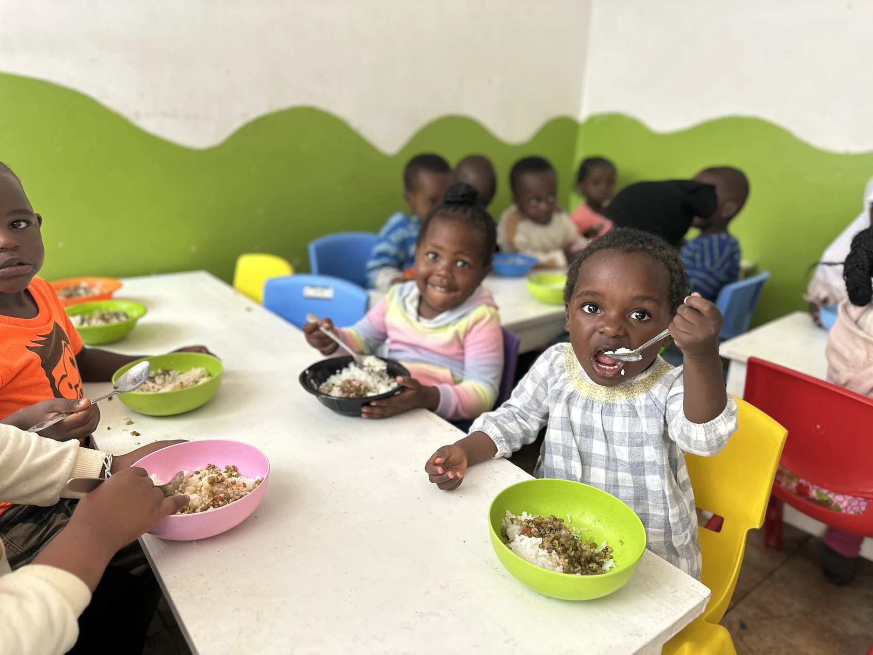 A smiling child seated with friends during a shared meal