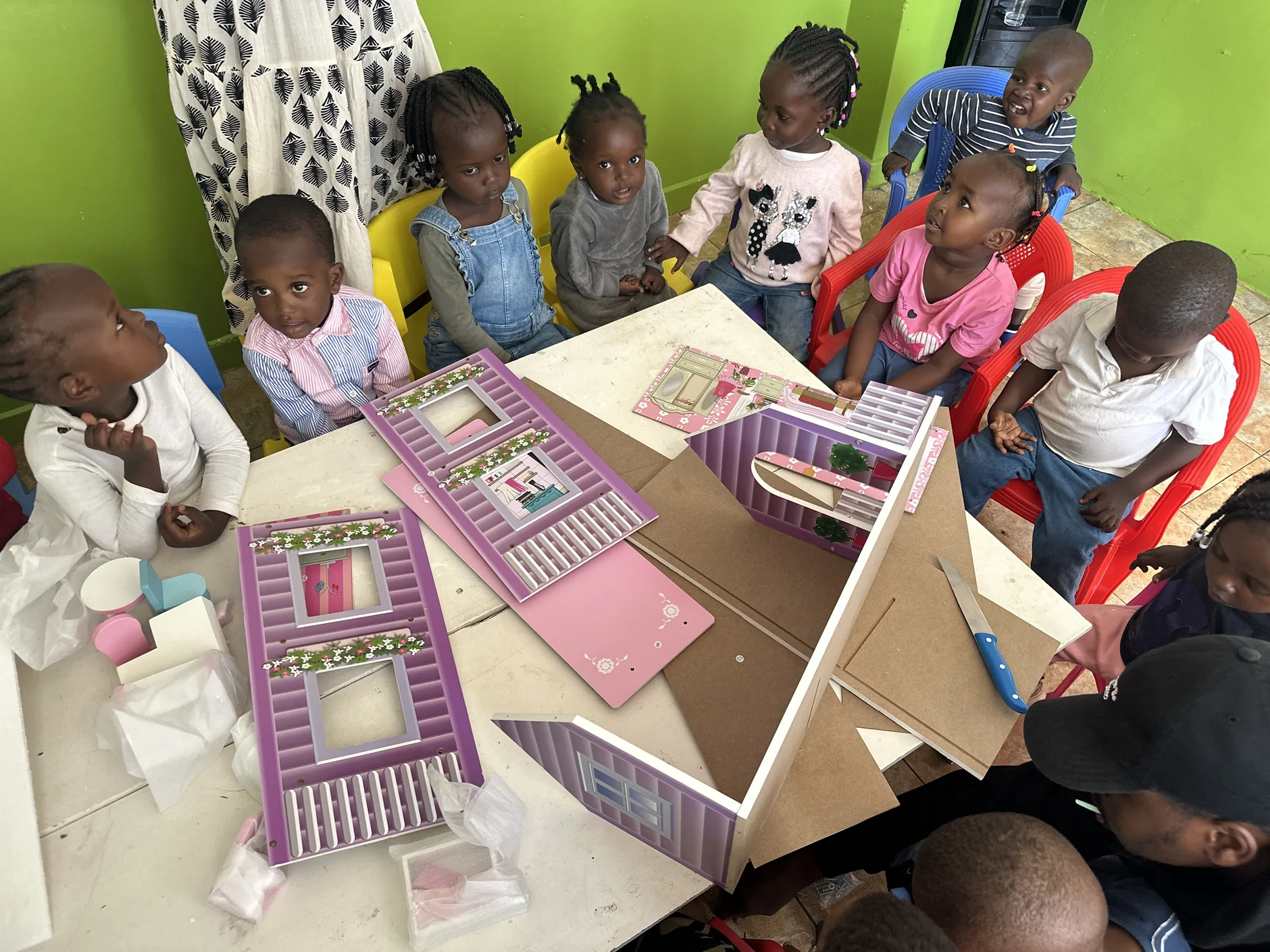 Children gathered around a hands-on learning activity at Little Heaven